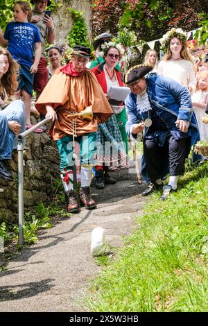 Randwick, Glos, Großbritannien. Mai 2024. Bürgermeister Brian Cratchley rollt den Käse. Randick WAP ist ein traditionelles Cotswold-Frühlingsfest. Die Maikönigin und der Bürgermeister werden an der Spitze einer kostümierten Prozession zum antiken Brunnen getragen. Es gibt Käserollen und einen Fayre. Das kleine Dorf Randwick liegt in den Cotswolds bei Stroud. Mit ihren Ursprüngen im Mittelalter endete die Feier, wurde aber in den 1970er Jahren vom örtlichen Vikar wiederbelebt. Quelle: JMF News/Alamy Live News Stockfoto