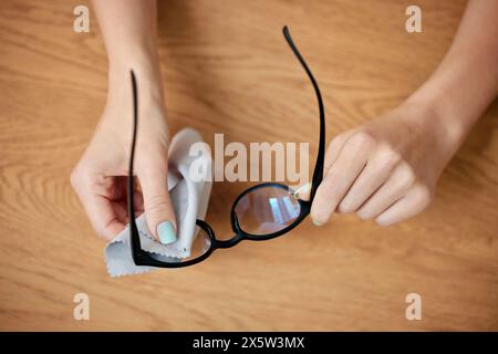 Staub, Brille und Tuch in den Händen zur Reinigung der Linse für die Sicht mit klarem Glas aus der Optometrie. Wischtuch, Rahmen und pflegeleichte Brille mit Seide Stockfoto