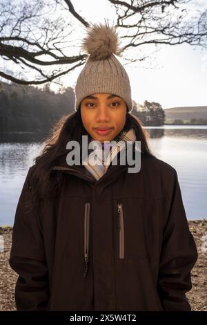 Porträt einer jungen Frau mit Strickmütze am See Stockfoto