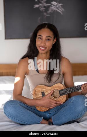 Porträt einer Ukulele spielenden jungen Frau Stockfoto
