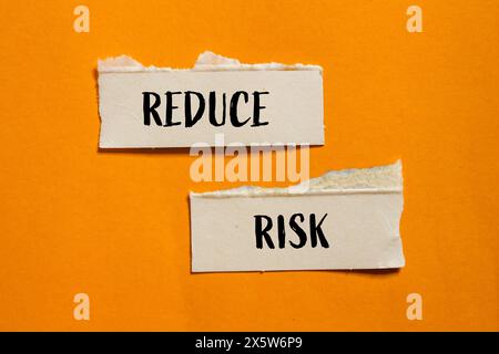 Vermeiden Sie das Risiko, dass Wörter auf gerissenen Papierstücken mit orangem Hintergrund geschrieben werden. Symbol für die konzeptionelle Risikoreduzierung. Kopierbereich. Stockfoto