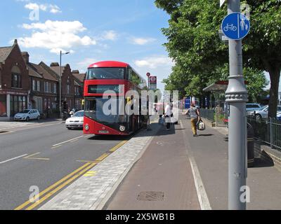 Passagiere, die an einer schwimmenden Bushaltestelle auf der Lee Bridge Road, Walthamstow, London ankommen. Die Leute müssen den Radweg überqueren, wenn sie aus dem Bus steigen. Stockfoto