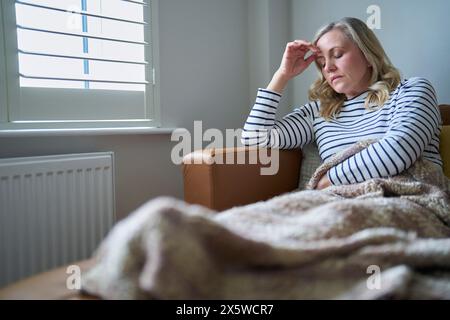 Reife Wirtschaftlich Inaktive Frau Mit Langzeitkrankheiten Sitzend Auf Sofa Zu Hause Stockfoto