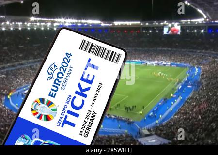 Deutschland - 1. Mai 2024: Ticket für das Logo der UEFA Euro 2024 Deutschland Fußball-Europameisterschaft Europa auf einem Handy in Stadionfotomontage in Deutschland. Stockfoto