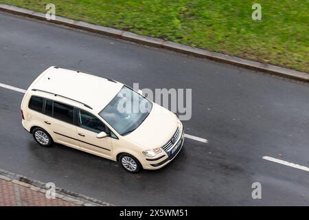 OSTRAVA, TSCHECHISCHE REPUBLIK - 23. MÄRZ 2024: Beigefarbener Volkswagen Touran MPV-Wagen mit Bewegungsunschärfe bei Regen Stockfoto