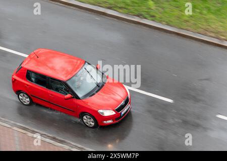 OSTRAVA, TSCHECHISCHE REPUBLIK - 23. MÄRZ 2024: Rotes Skoda Fabia II Fahrzeug mit Bewegungsunschärfe bei Regen in Draufsicht Stockfoto