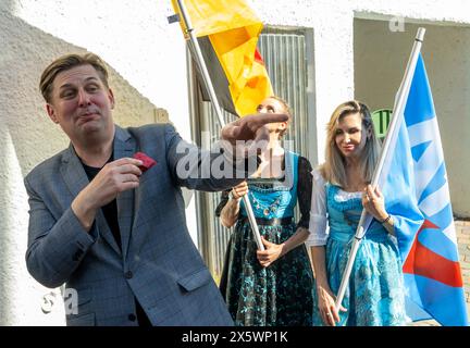 Holzkirchen, Deutschland. Mai 2024. Maximilian Krah, der Spitzenkandidat der AfD für die Europawahlen, gestikuliert neben zwei Frauen am Rande einer Wahlkampagne. Quelle: Stefan Puchner/dpa/Alamy Live News Stockfoto