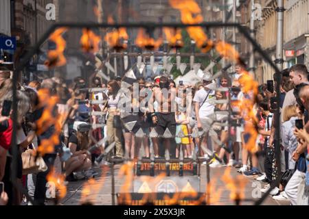 Glasgow, Schottland, Großbritannien. Mai 2024. Liam Collins, auch bekannt als Stunt Runner, springt durch Hürden aus Messern und Feuer, während die Augen verbunden sind. Gutschrift: R.. Gass/Alamy Live News Stockfoto