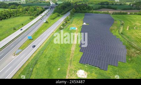 Drohnenflug auf einer deutschen Autobahn mit viel Verkehr und großen Solarpaneelen neben der Straße Stockfoto