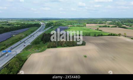 Drohnenflug auf einer deutschen Autobahn mit viel Verkehr und großen Solarpaneelen neben der Straße Stockfoto