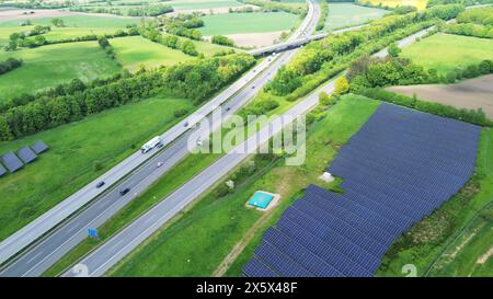 Drohnenflug auf einer deutschen Autobahn mit viel Verkehr und großen Solarpaneelen neben der Straße Stockfoto