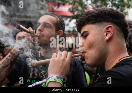 Madrid, Spanien. Mai 2024. Menschen, die während des globalen Marihuana-Marsches große Cannabisgelenke rauchen. Menschen marschieren durch das Stadtzentrum, um ein Gesetz für die Legalisierung von Cannabis zu fordern. Der globale Marihuana-Marsch findet jedes Jahr Anfang Mai in vielen Städten auf der ganzen Welt statt. Quelle: Marcos del Mazo/Alamy Live News Stockfoto