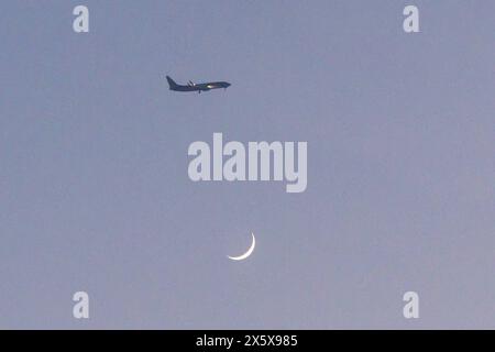 Ein Flugzeug im Landeanflug auf den Flughafen Oostende. Darunter der Mond mit einer sichbaren dünnen Sichel. Blick von der belgischen Küste am Strand Sint Andre in Koksijde Oostduinkerke 10.05.2024 Koksijde Oostduinkerke Westflandern Belgien *** ein Flugzeug nähert sich dem Flughafen Ostend unter dem Mond mit sichtbarer dünner Halbmond Ansicht von der belgischen Küste am Sint Andre Strand in Koksijde Oostduinkerke 10 05 2024 Koksijde Oostduinkerke Westflandern Westflandern Belgien Copyright: xBonn.digitalx/xMarcxJohnx Stockfoto