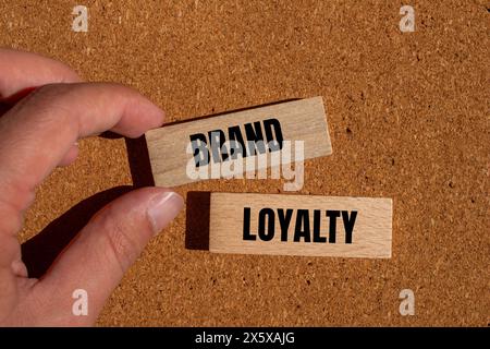 Markentreue auf Holzblöcken mit braunem Hintergrund. Konzeptionelles Symbol für Markenloyalität. Kopierbereich. Stockfoto