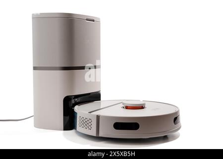 Ein weißer Roboter-Staubsauger befindet sich neben einem grauen Roboter-Staubsauger. Stockfoto