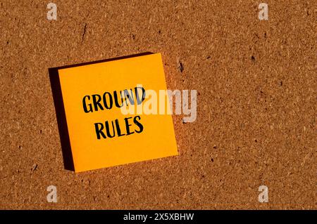 Grundregeln Wörter auf orangefarbenem Papieraufkleber mit braunem Hintergrund. Symbol für konzeptionelle Grundregeln. Kopierbereich. Stockfoto