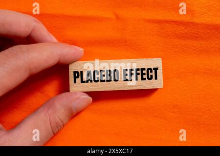 Plazebo-Effekt-Wörter auf Holzblock mit orangem Hintergrund. Konzeptuelles Plazebo-Effekt-Symbol. Kopierbereich. Stockfoto