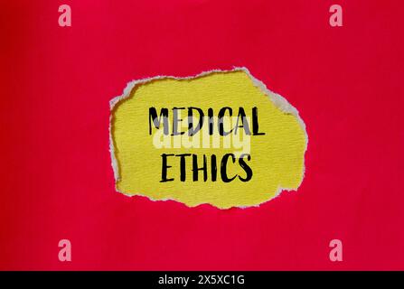 Medizinische Ethik-Wörter auf gerissenem rotem Papier mit gelbem Hintergrund. Konzeptuelles medizinisches Ethiksymbol. Kopierbereich. Stockfoto