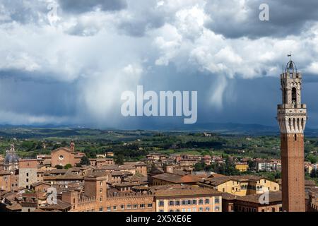 Blick auf den Torre del Mangia im Stadtzentrum des historischen Siena in der Toskana, Italien. Vom Aussichtspunkt Panorama dal Facciatone aus gesehen an einem stimmungsvollen Tag. Stockfoto