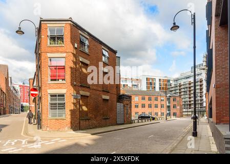 Alte Backsteingebäude, die in Wohnungen umgewandelt wurden, und neue Apartmenthäuser entlang der Kopfsteinpflasterstraßen im Zuge einer Stadterneuerung Stockfoto