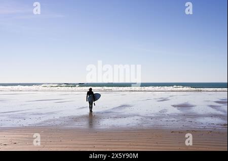 Einsamer Surfer mit Brett, um eine Welle zu fangen Stockfoto