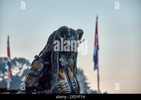 Baiona, Pontevedra, Galicien, Spanien, März, 2023; menschliche Statue auf der Straße, imitiert das eiserne Raubtier, mit Fahnen im Hintergrund Stockfoto