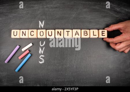 Unzählige Substantive. Kreuzworträtsel aus Holzblock und Kreideflächen auf einem Tafel-Hintergrund. Stockfoto