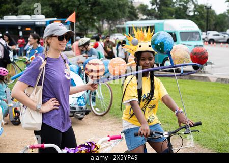 Houston, USA. Mai 2024. Ein Mädchen (R), das auf einem Kunstfahrrad zum Thema Sonnensystem fährt, wird auf dem 3rd Art Bike Parade & Festival in Houston, Texas, USA, am 11. Mai 2024 gesehen. Die jährliche Veranstaltung zog Hunderte von Menschen an, um ihre Kreativität bei der Entwicklung von Fahrrädern zu demonstrieren und verschiedene Aktivitäten zu genießen. Quelle: Chen Chen/Xinhua/Alamy Live News Stockfoto