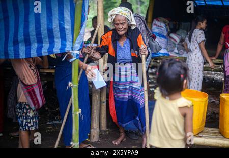 Myawaddy, Myanmar. Mai 2024. Eine ältere Dame geht zurück zu ihrem Zelt, nachdem sie den medizinischen Dienst erhalten hat. Myawaddy-Kriegsflüchtlinge leben im Wald wegen des Krieges zwischen der Widerstandsgruppe und der birmanischen Armee. Die burmesische Armee setzte Motorbomben und Luftangriffe ein. Deshalb fliehen viele Menschen von ihrem Wohnort. Manche Leute, die sich die teuren Lasten leisten konnten, fliehen nach Mae sot, Thailand. Aber für die Leute, die sich das nicht leisten konnten, lebten sie im Dschungel. (Foto: Kaung Zaw Hein/SOPA Images/SIPA USA) Credit: SIPA USA/Alamy Live News Stockfoto