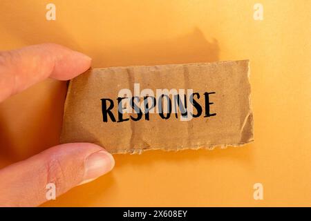 Antwortwort auf gerissenem Papppapier mit orangem Hintergrund geschrieben. Symbol für konzeptionelle Antwort. Kopierbereich. Stockfoto