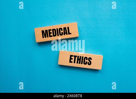 Medizinische Ethik Wörter auf Holzblöcken mit blauem Hintergrund geschrieben. Konzeptuelles medizinisches Ethiksymbol. Kopierbereich. Stockfoto