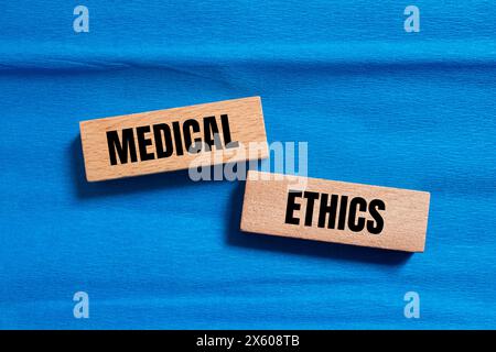 Medizinische Ethik Wörter auf Holzblöcken mit blauem Hintergrund geschrieben. Konzeptuelles medizinisches Ethiksymbol. Kopierbereich. Stockfoto
