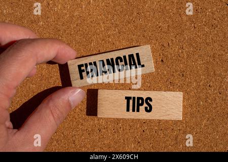 Finanztipps auf Holzblöcken mit braunem Hintergrund. Symbol für konzeptionelle Finanztipps für Unternehmen. Kopierbereich. Stockfoto