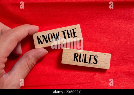 Kennen Sie die Regeln, die auf Holzblöcken mit rotem Hintergrund geschrieben sind. Das Symbol Regeln kennen. Kopierbereich. Stockfoto