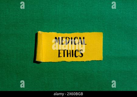 Medizinische Ethik Wörter geschrieben auf gerissenem gelbem Papier mit grünem Hintergrund. Konzeptuelles medizinisches Ethiksymbol. Kopierbereich. Stockfoto