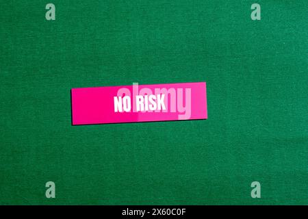 Keine Risikowörter auf rosafarbenem Papieraufkleber mit grünem Hintergrund. Konzeptionelles „kein Risiko“-Symbol. Kopierbereich. Stockfoto