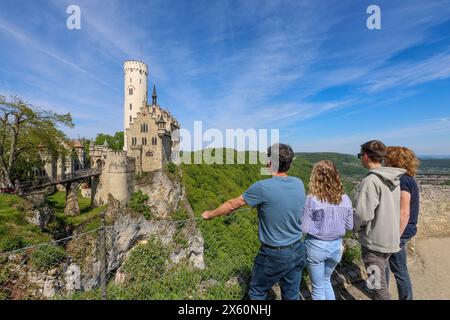 Lichtenstein, Deutschland. Mai 2024. Ausflügler stehen auf einer Aussichtsplattform und blicken über das Schloss Lichtenstein auf der Schwäbischen Alb. Autor: Thomas Warnack/dpa/Alamy Live News Stockfoto