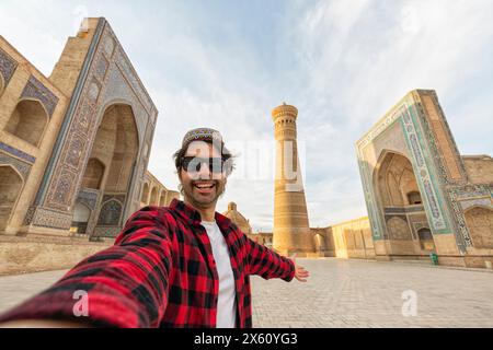 Glücklicher Tourist, der ein Foto von Buckara vor dem berühmten Platz macht - Reisekonzept Stockfoto