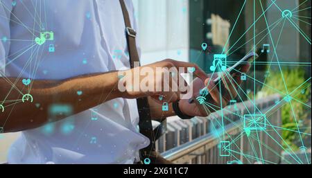 Bild der verbundenen Symbole wird über der Mitte des birassischen Mannes dargestellt, der auf dem Smartphone scrollt Stockfoto