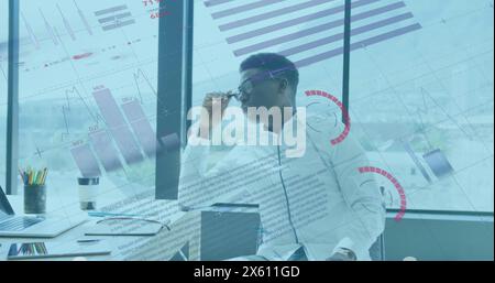 Bild der Datenverarbeitung über afroamerikanischen Geschäftsmann, der im Büro arbeitet Stockfoto