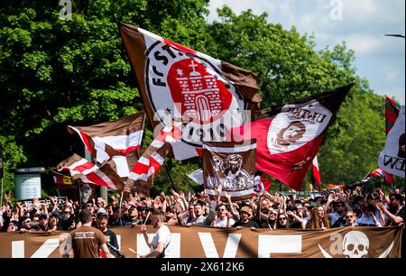 Hamburg, Deutschland. Mai 2024. Fußball: Bundesliga 2, Spieltag 33: FC St. Pauli - VfL Osnabrück im Millerntorstadion. Hamburger Fans laufen mit Fahnen ins Stadion. Quelle: DPA/dpa/Alamy Live News Stockfoto