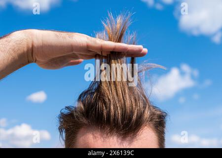 Männerhaar. Durchschnittliches Haar eines Mannes, der Länge zeigt Stockfoto