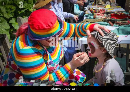 London, Großbritannien. Mai 2024. Lily, 8, feiert ihren 8. Geburtstag mit einer Facepainting-Session von einem der Künstler. Puppenspieler aus dem ganzen Land treffen sich zum jährlichen Maifest Fayre und Puppet Festival. Sie findet auf dem Gelände der St. Paul's Church (auch Schauspielerkirche genannt), Covent Garden, statt und umfasst einen Gottesdienst, eine Prozession, Punsch- und Judy-Shows, Workshops, Stände und Familienspaß. Quelle: Imageplotter/Alamy Live News Stockfoto