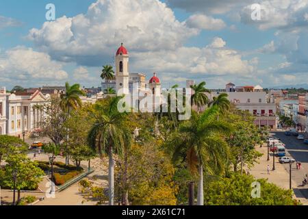 CIENFUEGOS, KUBA - 13. JAN 2022 - Kathedrale der Unbefleckten Empfängnis. 2005 wurde Cienfuegos zum UNESCO-Weltkulturerbe erklärt. Palmen mit einem Kirchturm im Hintergrund in der Altstadt Stockfoto