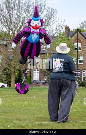 London, Großbritannien. 12. Mai 2024. Simon Hennessy von Brighton Kite Flyers fliegt seinen riesigen Clowndrachen, während Drachenflieger am 23. Streatham Common Kite Day teilnehmen. Die beliebte Veranstaltung bringt Kite-Enthusiasten nach Streatham Common, darunter Experten und Familien, die einen Tag ausklingen möchten. Quelle: Stephen Chung / Alamy Live News Stockfoto