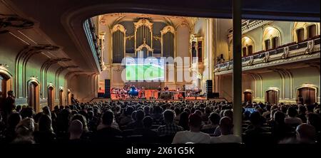 Hamburg, Deutschland. Mai 2024. Das Projekt „das Spiel“ setzt das Fußballspiel zwischen dem Zweitligisten FC St. Pauli und dem VfL Osnabrück live in der Laiszhalle auf. Das Ensemble Resonanz und die Band des elektronischen Künstlers Matthew Herbert treten gegeneinander an. Jeder Standard hat seine eigene Melodie. So entsteht das Libretto für das Konzert auf dem Spielfeld. Quelle: Markus Scholz/dpa/Alamy Live News Stockfoto