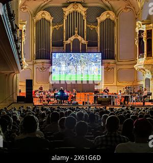 Hamburg, Deutschland. Mai 2024. Das Projekt „das Spiel“ setzt das Fußballspiel zwischen dem Zweitligisten FC St. Pauli und dem VfL Osnabrück live in der Laiszhalle auf. Das Ensemble Resonanz und die Band des elektronischen Künstlers Matthew Herbert treten gegeneinander an. Jeder Standard hat seine eigene Melodie. So entsteht das Libretto für das Konzert auf dem Spielfeld. Quelle: Markus Scholz/dpa/Alamy Live News Stockfoto