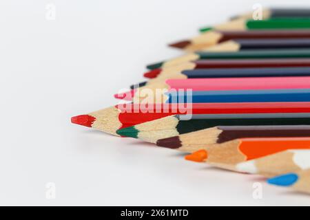 Mehrfarbige Bleistifte schräg auf weißem Hintergrund gefaltet. Geringe Schärfentiefe Stockfoto