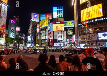 Tokio, Japan, 14. April 2024: Touristen, die nachts durch die Straßen Tokios laufen, in der Gegend von Shibuya. Stockfoto