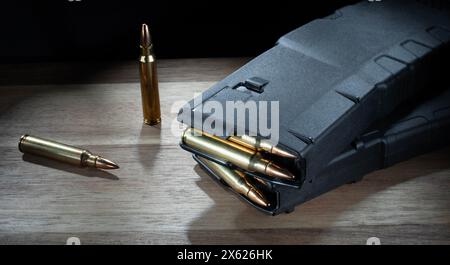 Zwei Kassetten auf dem Tisch neben AR-15 Magazinen mit hoher Kapazität und voller Munition. Stockfoto